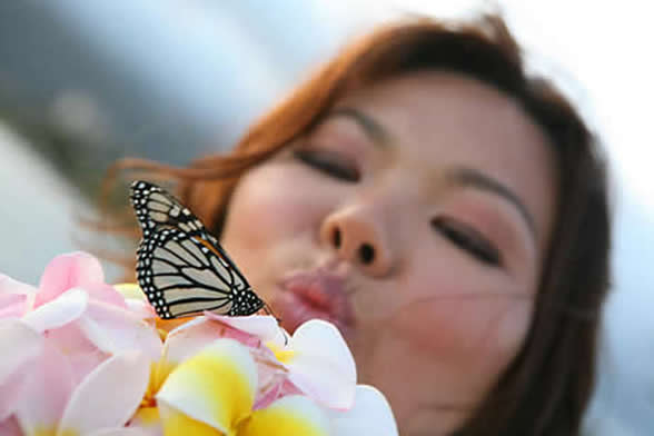 bride blows a kiss to the butterfly that just landed on her bouquet